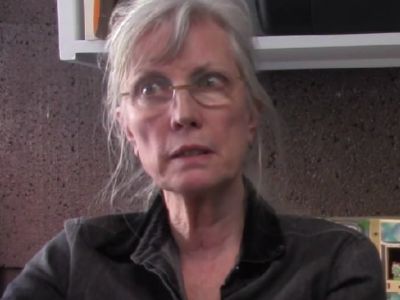 Elizabeth LeCompte is wearing a black jacket and glasses.